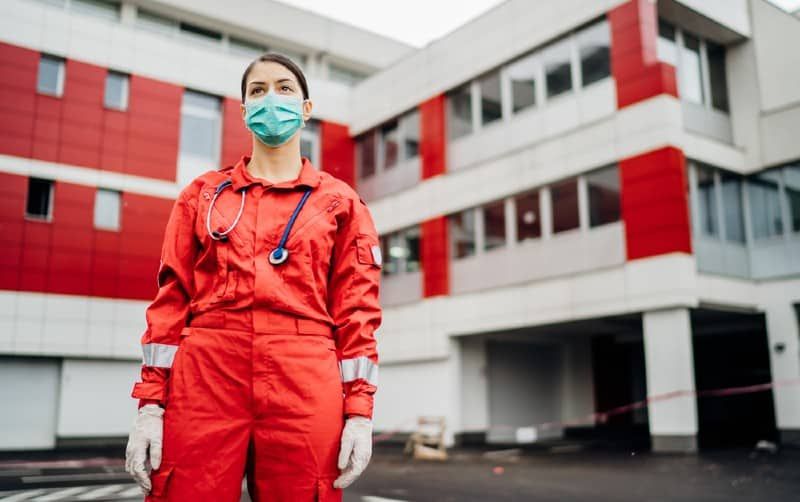 Krankenschwester vor dem Krankenhaus in rotem Kostüm gekleidet