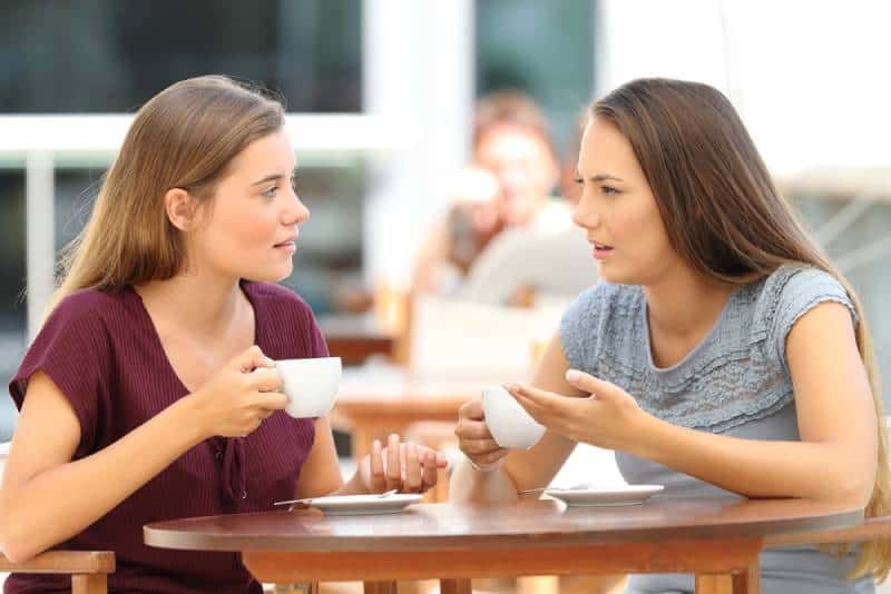 Zwei ernsthafte Freunde unterhalten sich, während sie in einem Restaurant sitzen