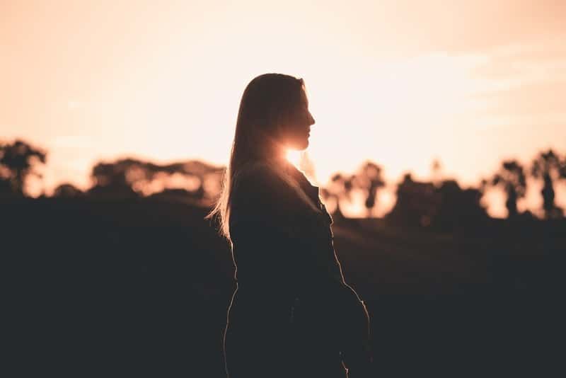 Silhouette einer Frau in einer Seitenansicht während der goldenen Stunde
