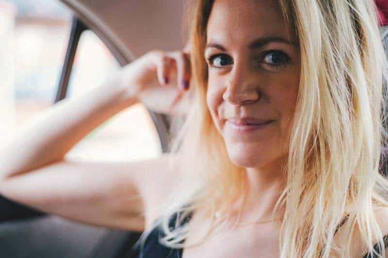 Blonde Frau lächelt im Auto