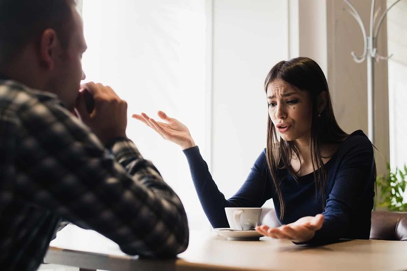 Eine Frau führt ein ehrliches Gespräch mit einem Mann, während sie im Café sitzt