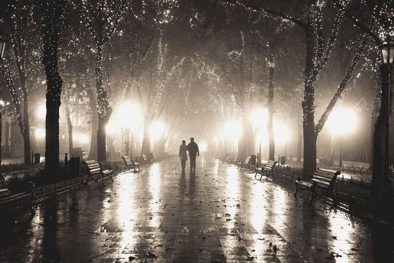 Ein Paar spaziert in einer Gasse im Nachtlicht in der Ferne