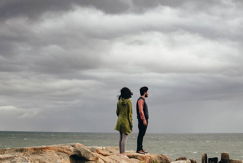 Mann und Frau stehen auf einer Klippe am Meer