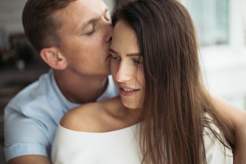 Mann küsst Frau auf die Stirn