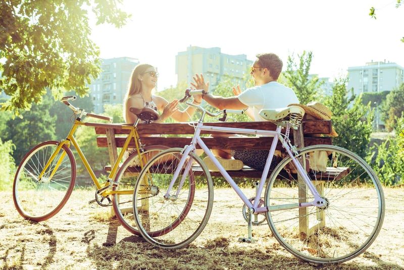 Paar ruht sich auf einer Bank mit zwei Fahrrädern aus und hat eine gute Zeit