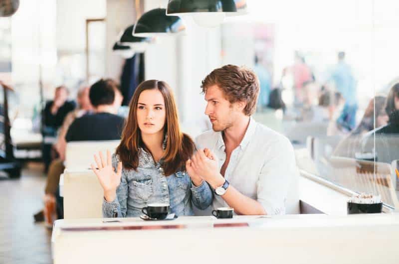Junges Paar flirtet an der Bar, während es der Frau nicht gefällt