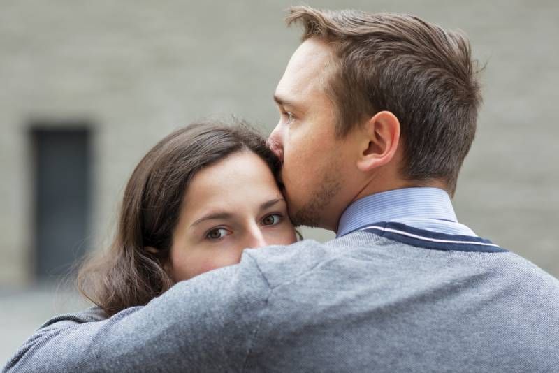 Mann küsst ihre besorgte Freundin draußen