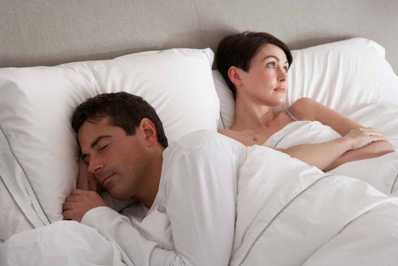 Mann schläft im Bett, während Frau verrückt ist