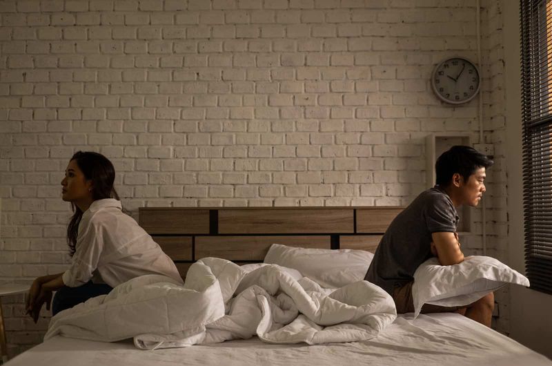 junges Paar sitzt auf dem Bett