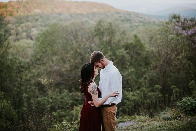Mann und Frau küssen sich tagsüber im Wald