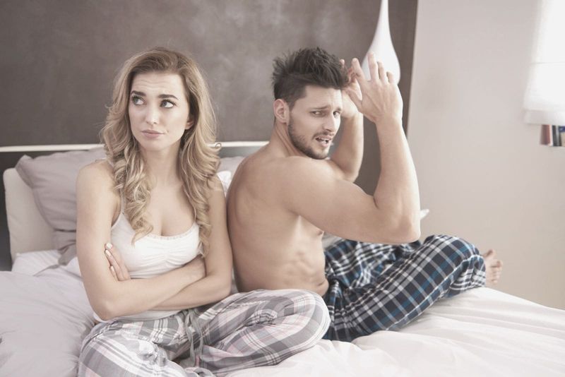 Streitendes Paar am Morgen im Schlafanzug im Bett sitzend