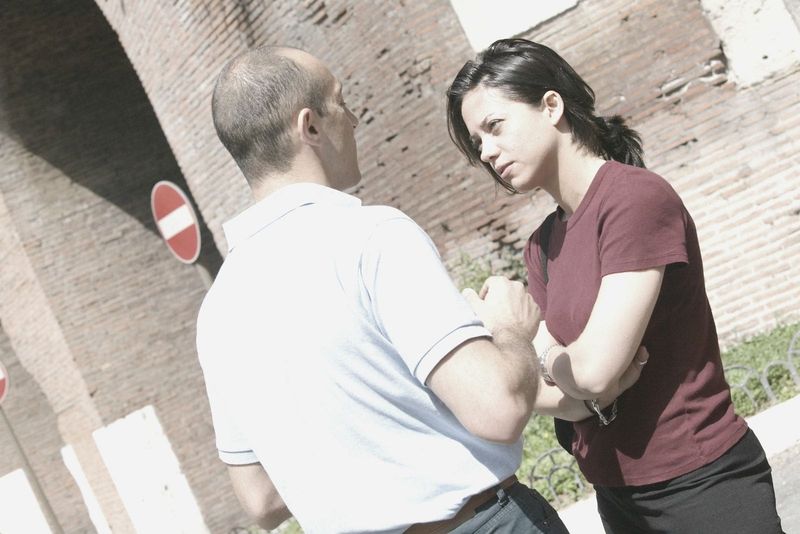 Paar streitet außerhalb des Gebäudes mit roten Backsteinmauern