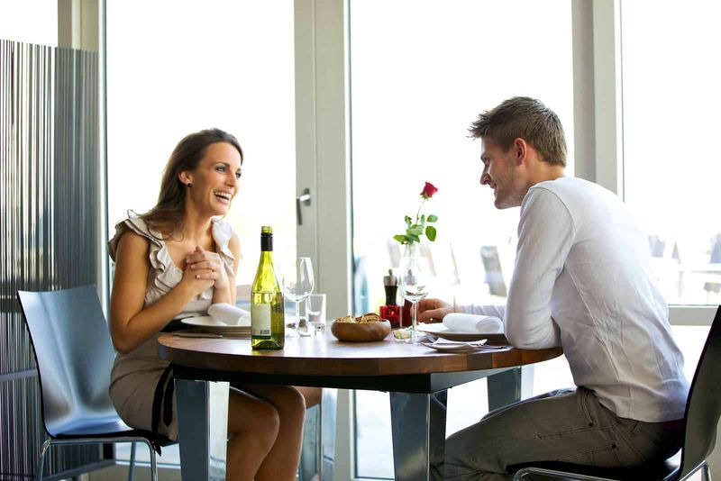 Ein lächelnder Mann und eine Frau sitzen in einem Café