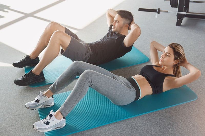 Junges Paar trainiert gemeinsam im Fitnessstudio für einen gesunden Lebensstil