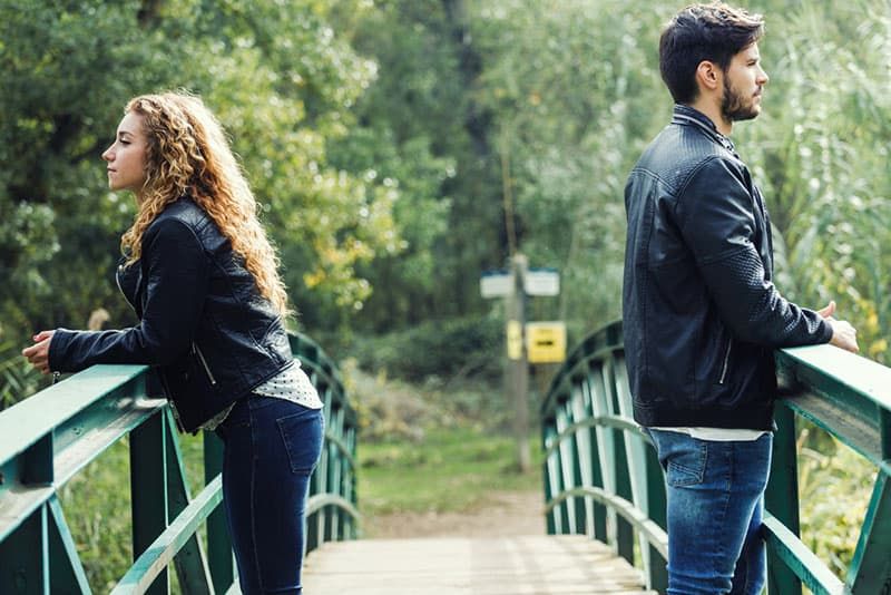 junges Paar in einem Konflikt auf einer Brücke