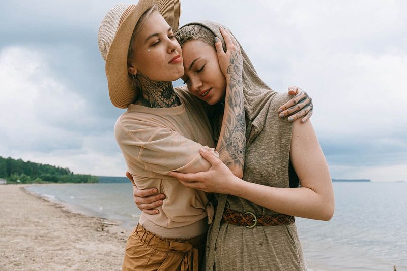 Zwei Freundinnen umarmen sich am Strand