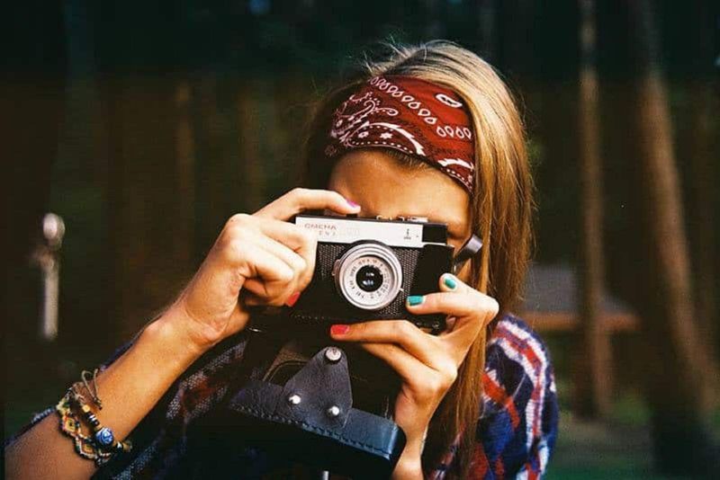 Frau macht ein Foto mit ihrer Kamera