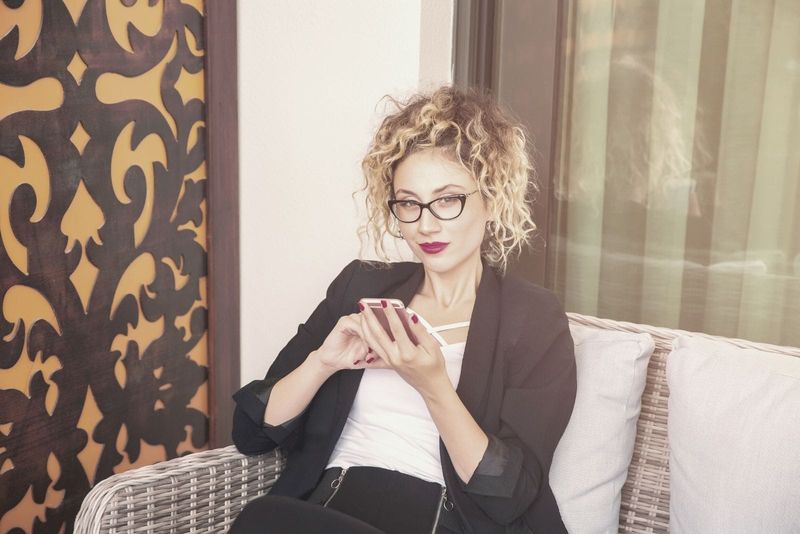 Geschäftsfrau Social-Media-Konzept einer Frau mit einem Telefon und drinnen sitzen