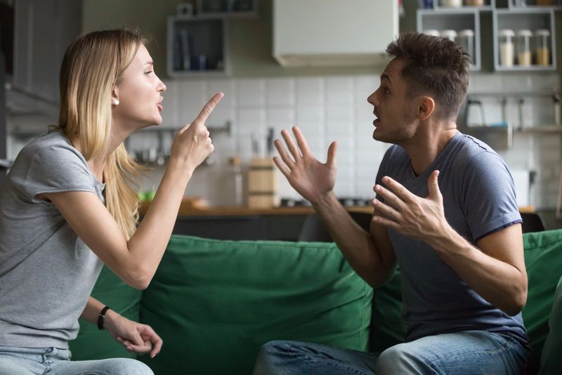 Mann und Frau streiten sich, während sie auf dem Sofa sitzen