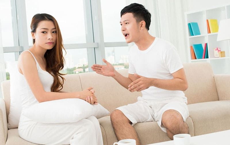 Asiatisches Paar streitet auf dem Sofa im Wohnzimmer