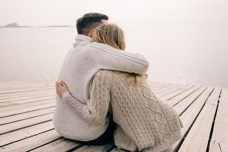 Paar umarmt sich auf einem Pier