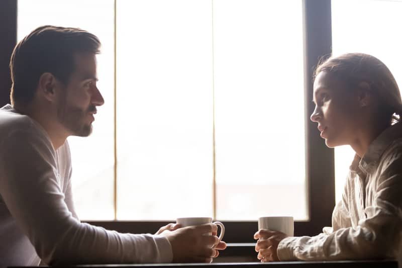 Ernsthaftes Paar unterhält sich bei einer Tasse Kaffee in einem Café