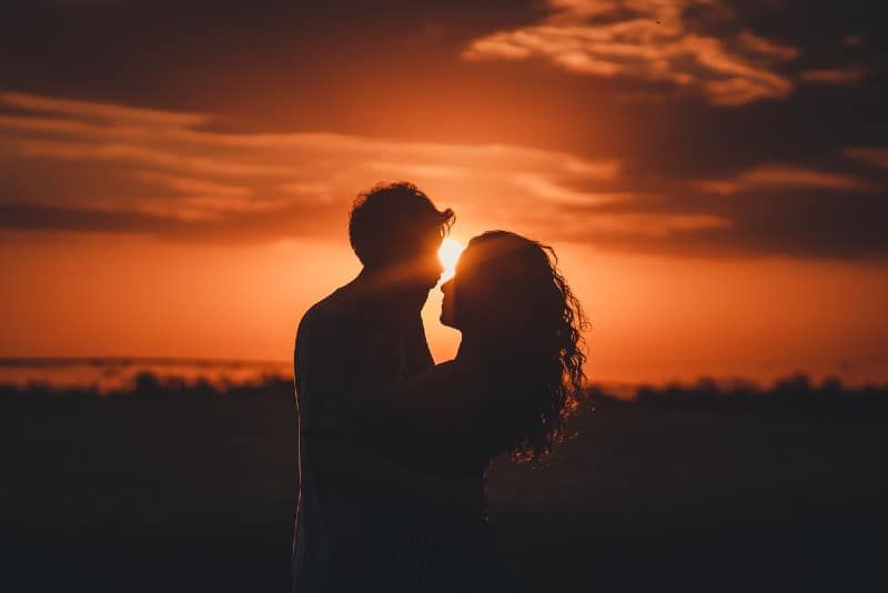 Mann und Frau nehmen bei Sonnenuntergang Augenkontakt auf