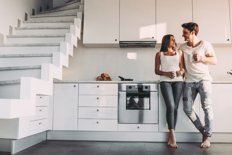 Ein Mann und eine Frau stehen nebeneinander und lehnen sich an die Küche