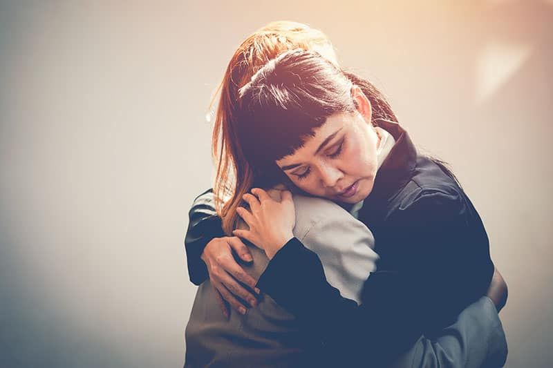 Zwei Frauen umarmen sich, um zu trösten