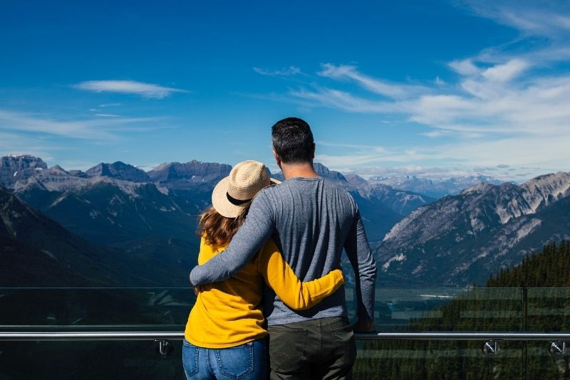 Mann und Frau umarmen sich, während sie auf den Berg schauen