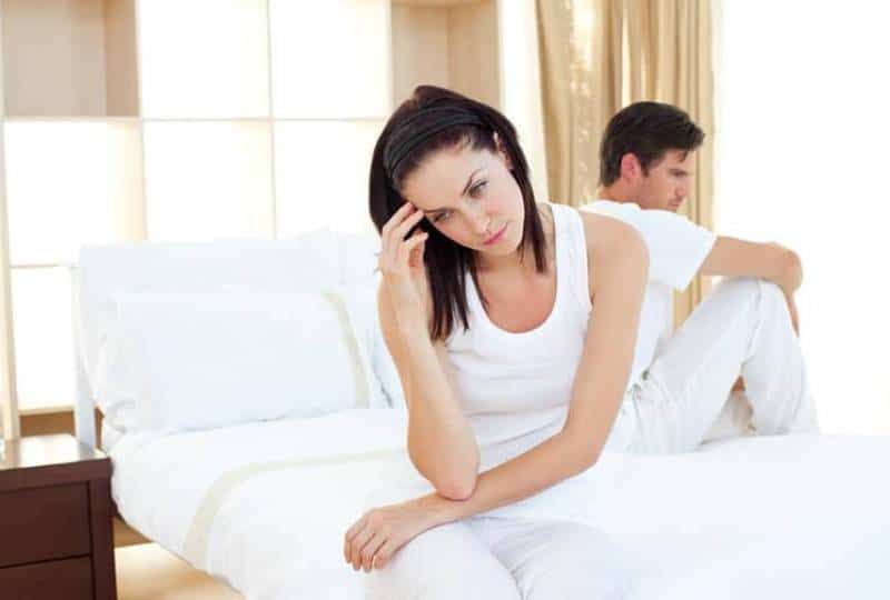 Verärgertes Paar erfährt im Schlafzimmer die Ergebnisse eines Schwangerschaftstests