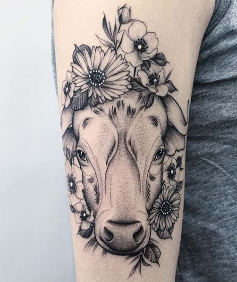 Stier-Tattoo, umgeben von Blumen auf dem Arm