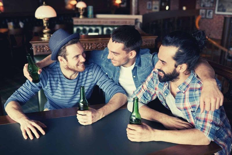 glückliche männliche freunde, die bier trinken und rumhängen