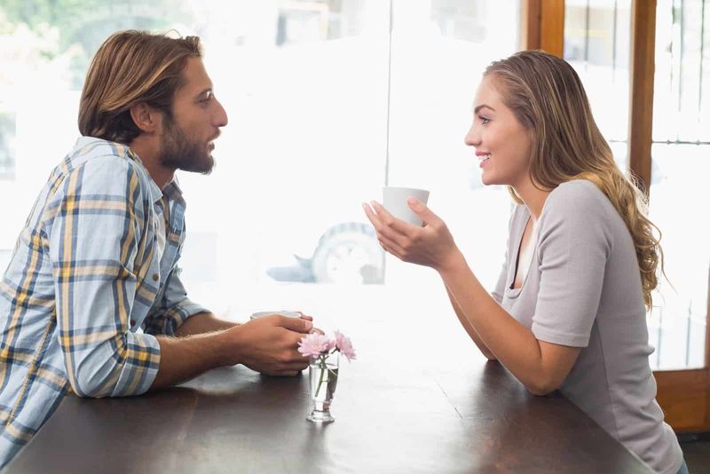Mann spricht mit Frau, während er im Café sitzt