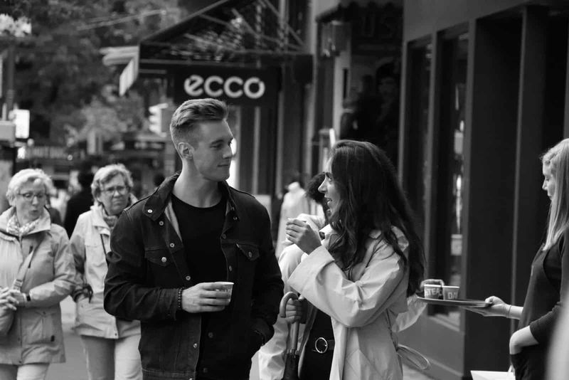 Mann und Frau nehmen Augenkontakt auf, während sie im Freien Kaffee trinken