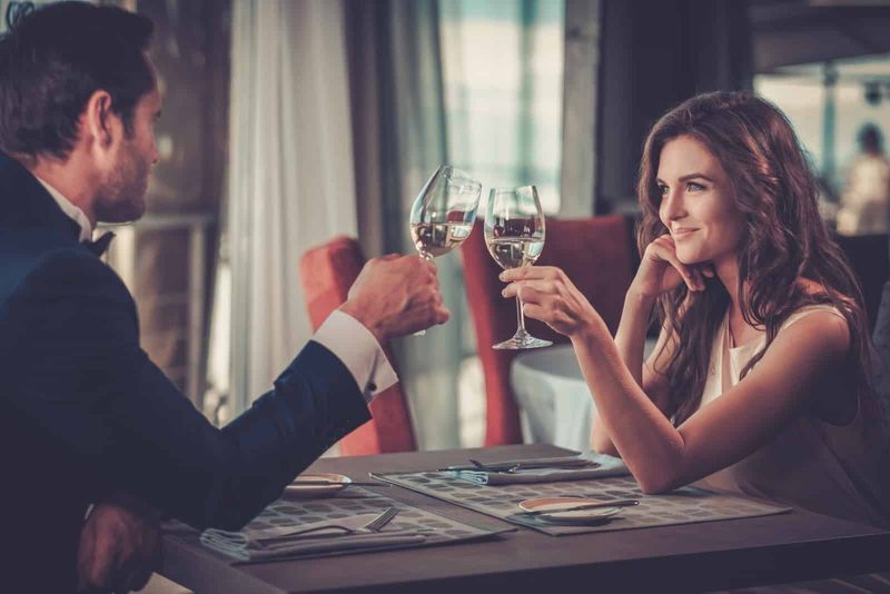 Mann und Frau stoßen während eines romantischen Abendessens mit Weingläsern an